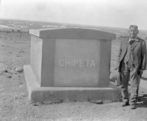 A man wearing a suit stands beside Chipeta's grave.