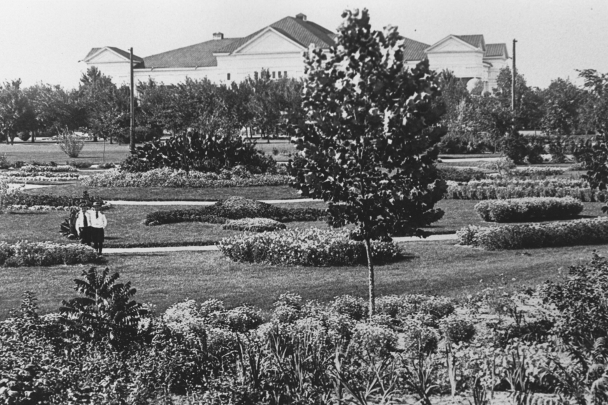 A view of Mineral Palace Park showing flower beds, trees, and the huge Mineral Palace rising over it all.