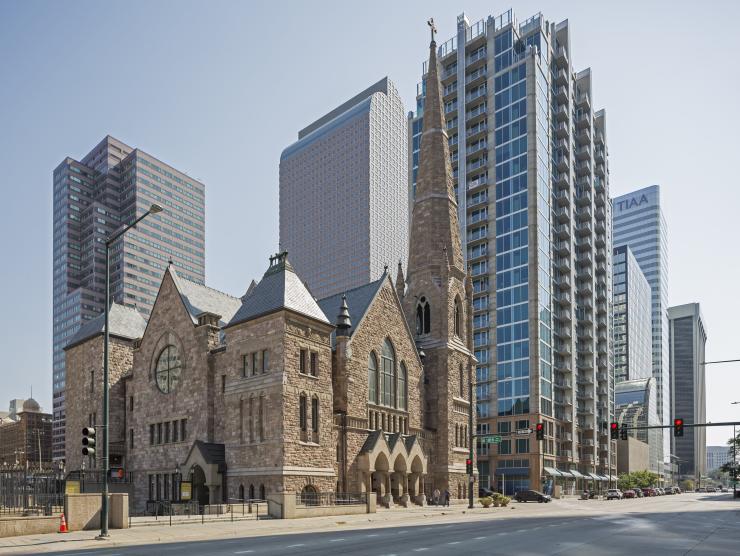 Photo of an old church and a modern building next to each other
