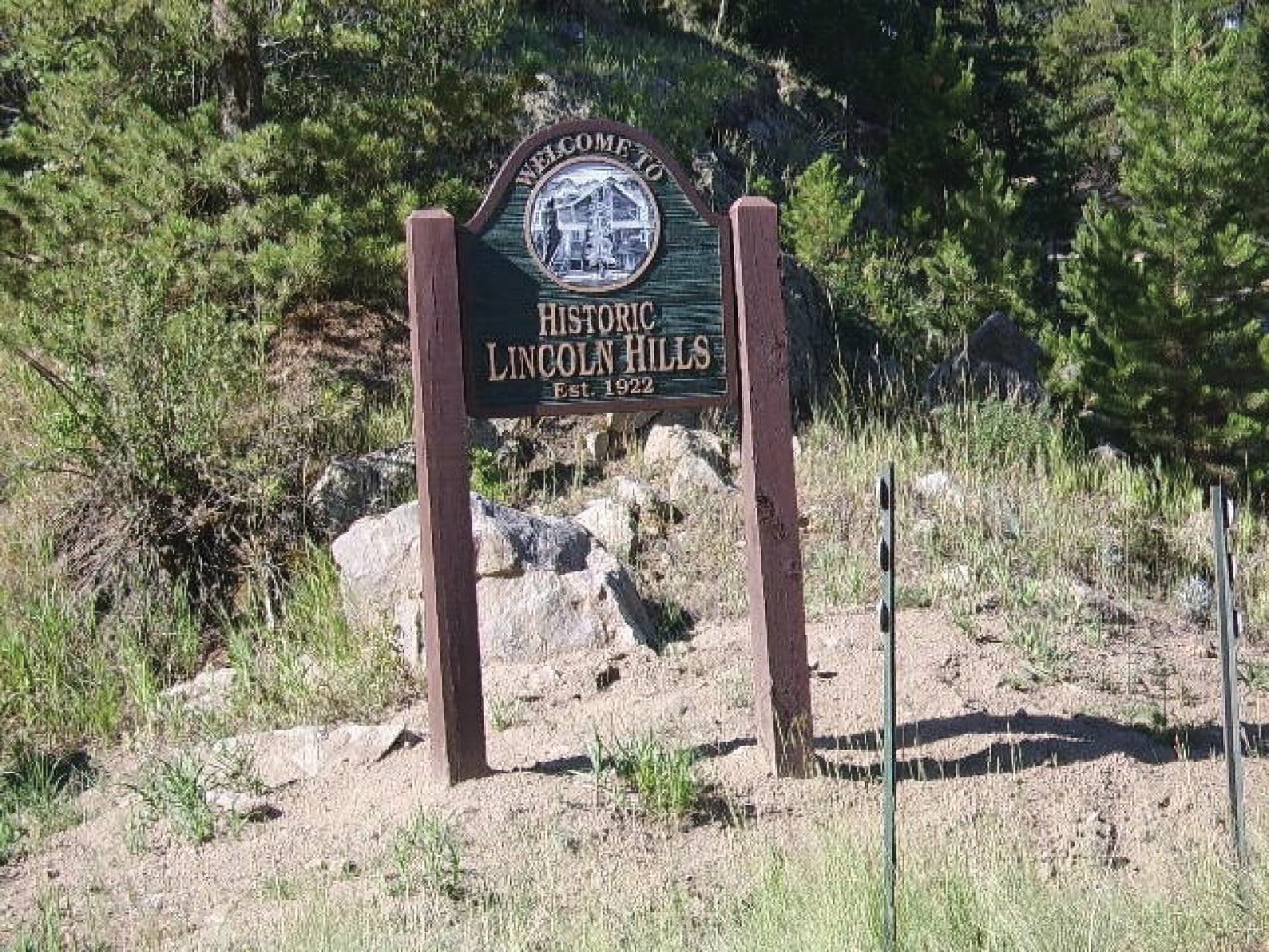 A sign by a trail reading: "Welcome to Historic Lincoln Hills, Established 1922."