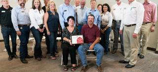 Carpenter-Newbanks Farms family members (seated) with their certificate.