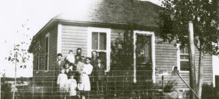 Family standing in front of the farmhouse in 1916.