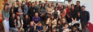 A large, diverse group of participants smiling at the camera with adults and children. Part of the Little Saigon memory project.