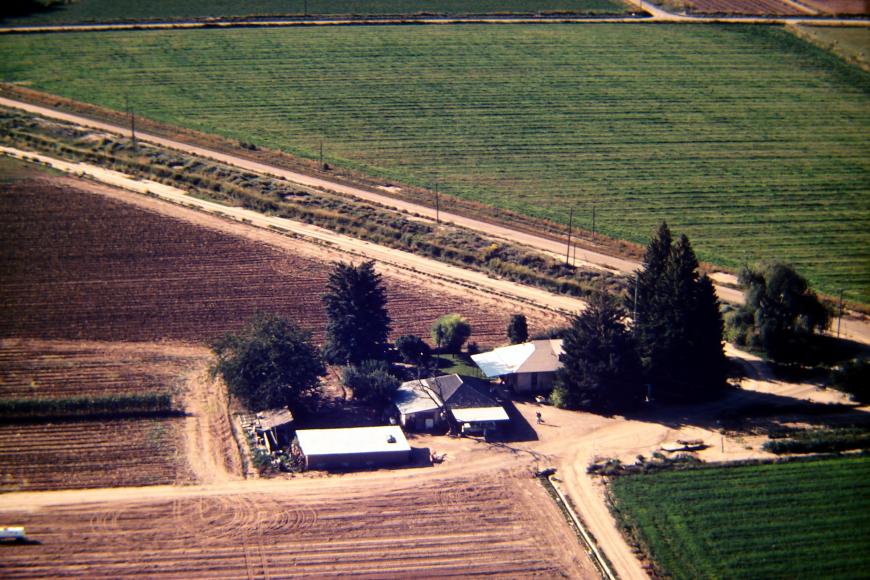 Aerial view of the Westesen Farm, 1983, with Dan Westesen flying the plane and Harold Westersen waving up at it.