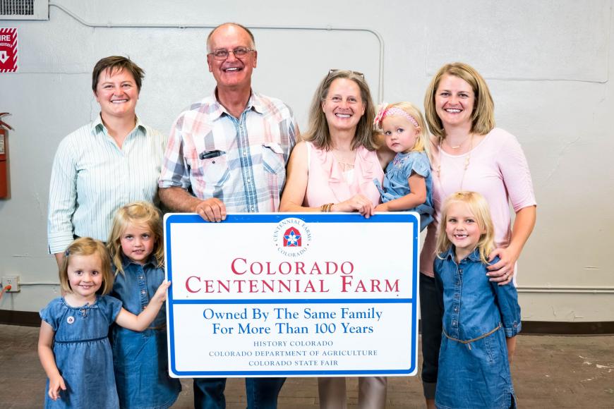 The Carlson Farm family with their Centennial Farm sign.