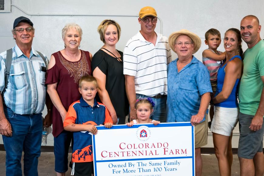Pearl family with their Centennial Farms sign.