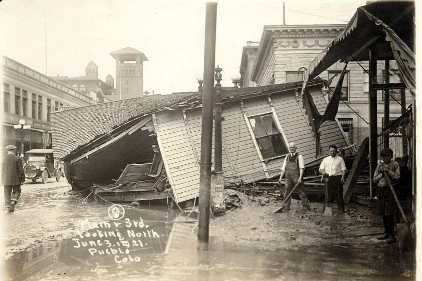 Shoveling mud by destroyed house after 1921 Pueblo Flood