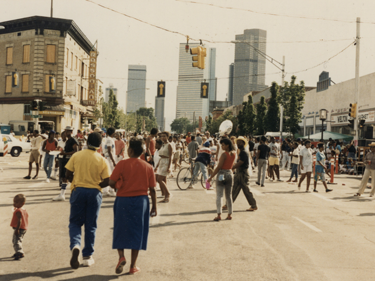 Historic color photo of people on a street with the Blaxplanation series logo superimposed